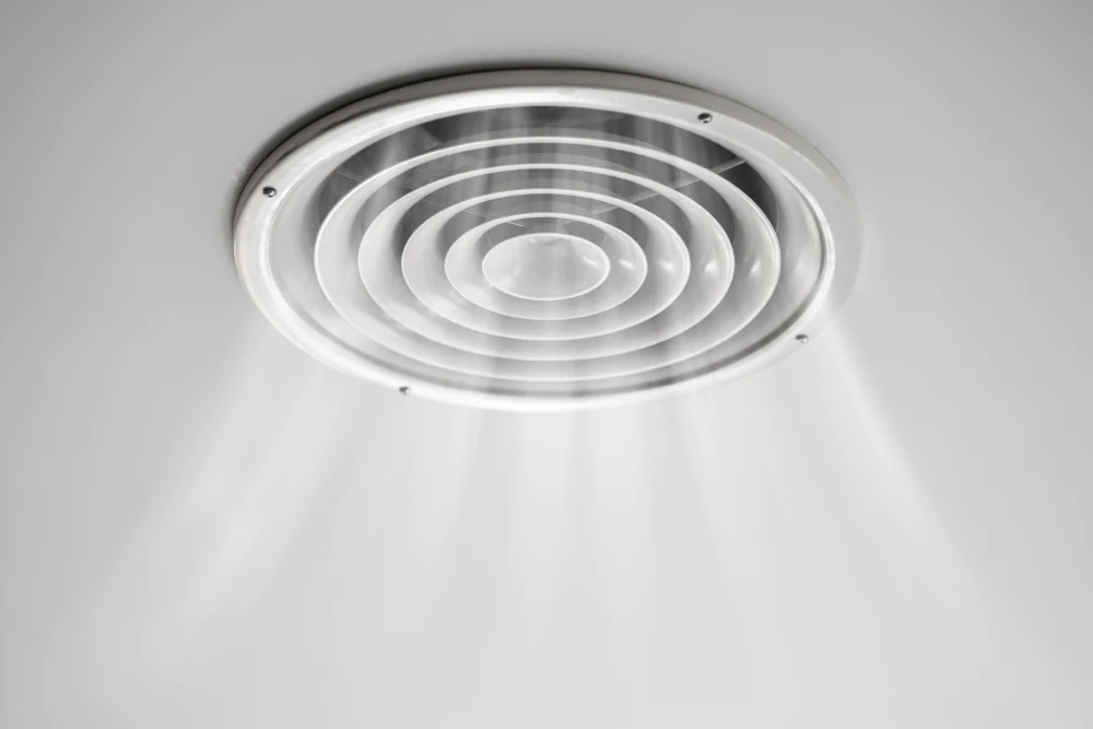 Bild von einer Lüftungsanlage an einer Decke, aus der Luft strömt